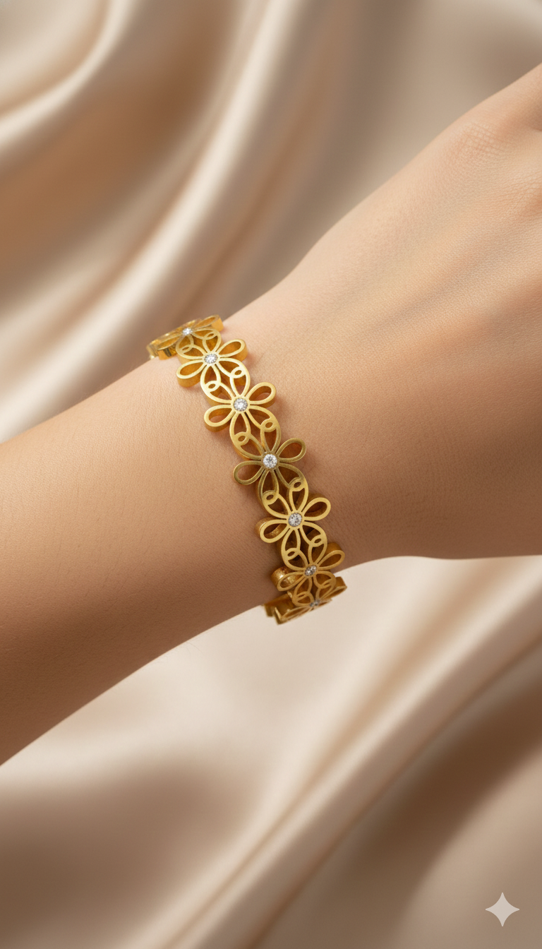 Gold floral bracelet on a wrist against a beige satin background