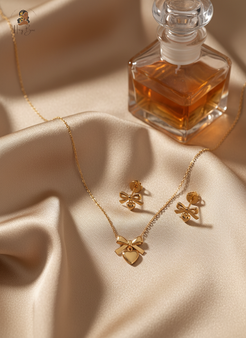 Gold necklace and earrings with a perfume bottle on a beige fabric background