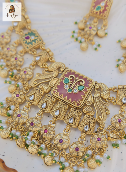 Ornate gold necklace with gemstones on a light background