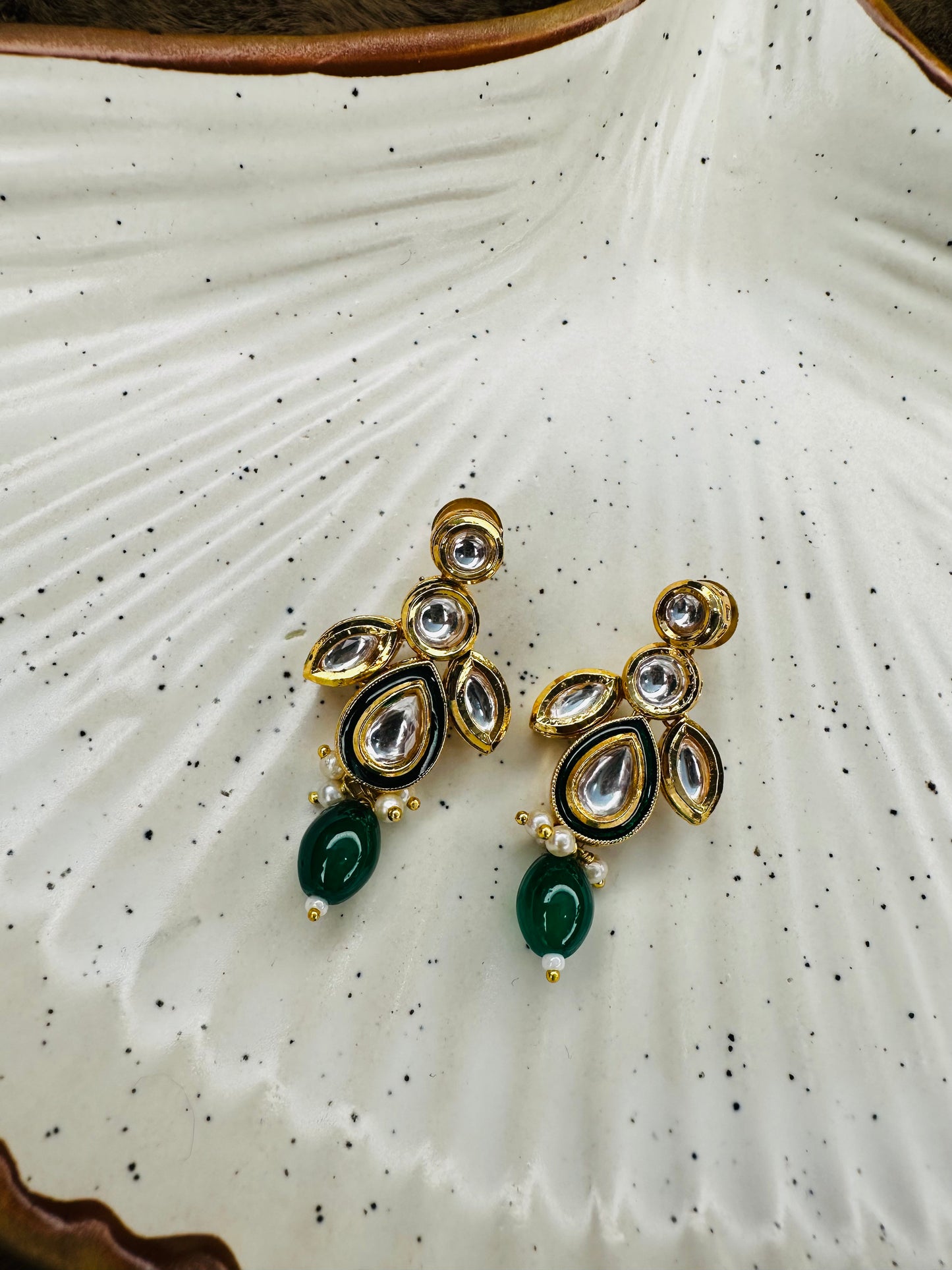 Model shot side profile wearing green kundan set