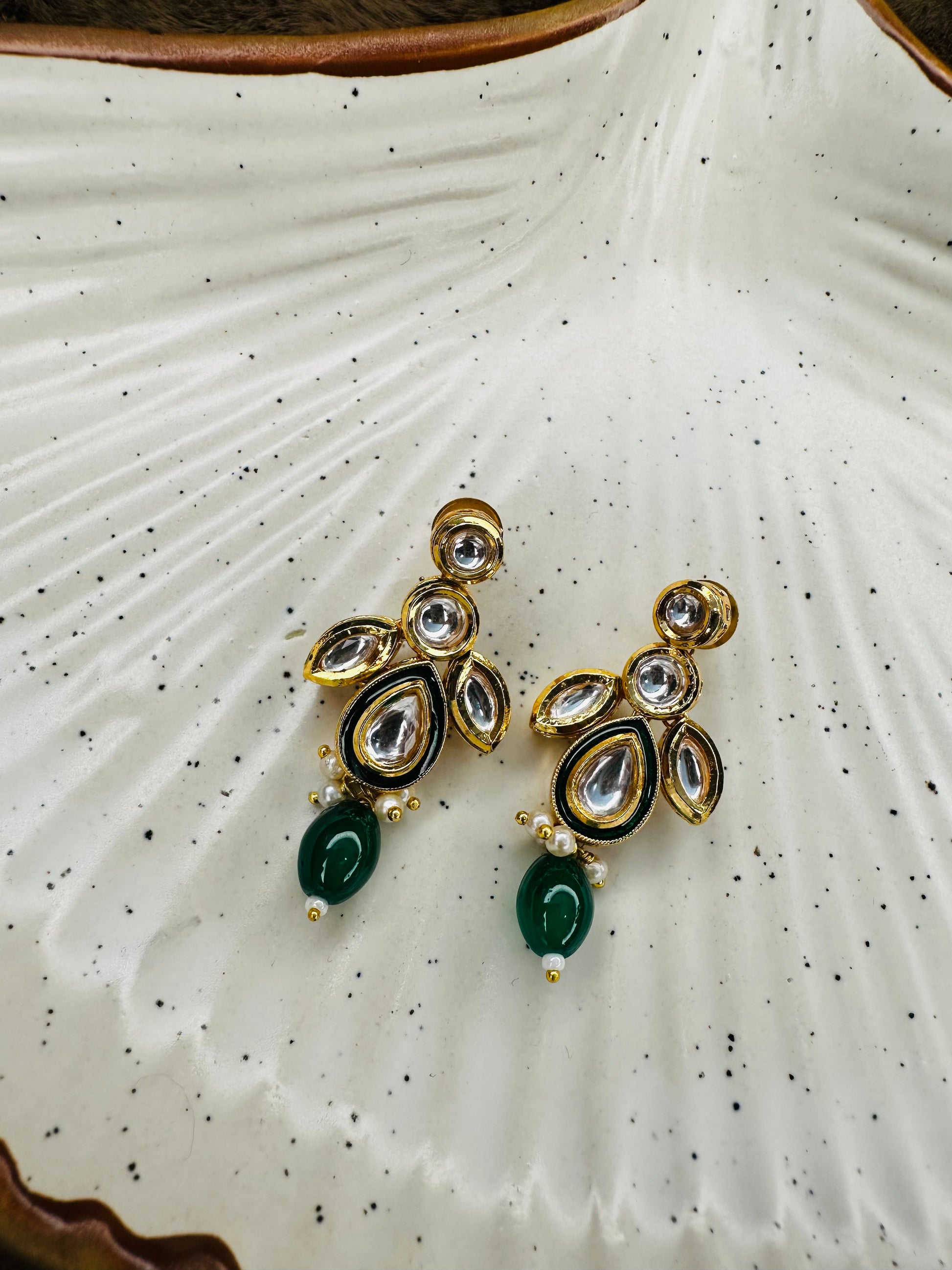 Model shot side profile wearing green kundan set
