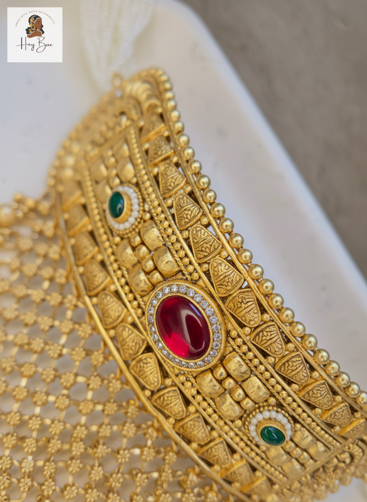 Close up of antique gold mesh work and kemp stone detailing on Indian choker necklace.