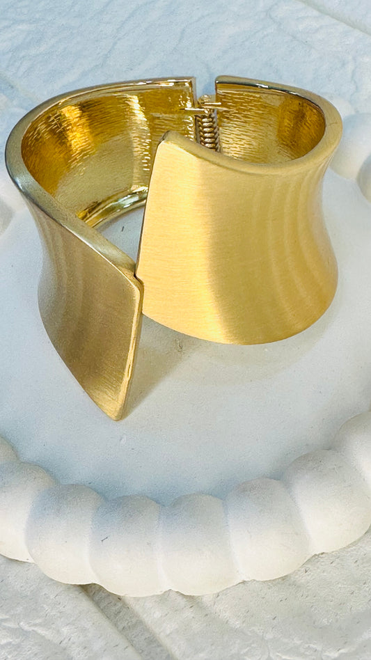 Side angle of geometric gold cuff bracelet with sculptural design