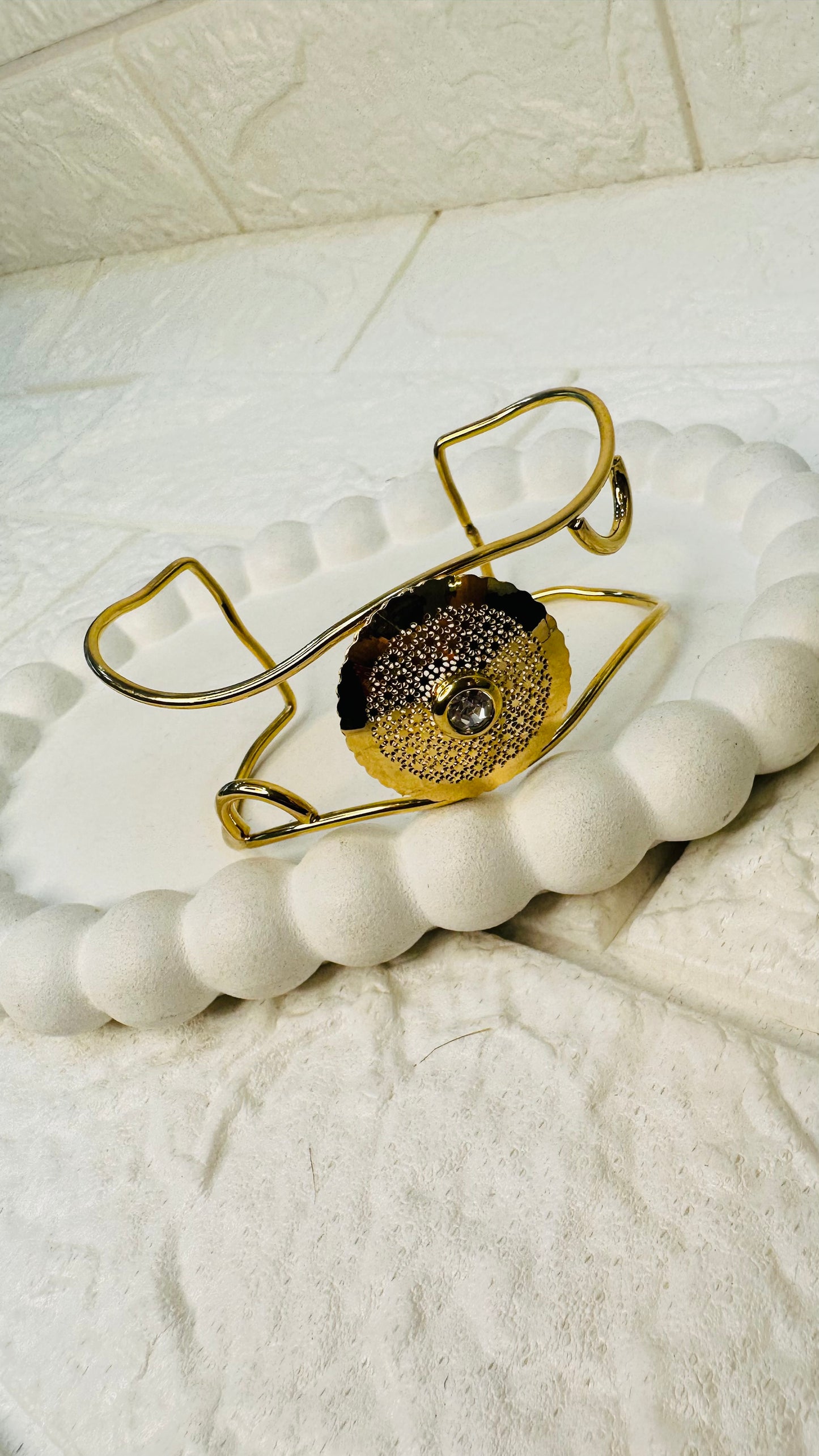 Wide display of gold disc pearl cuff bracelet on neutral background for festive wear