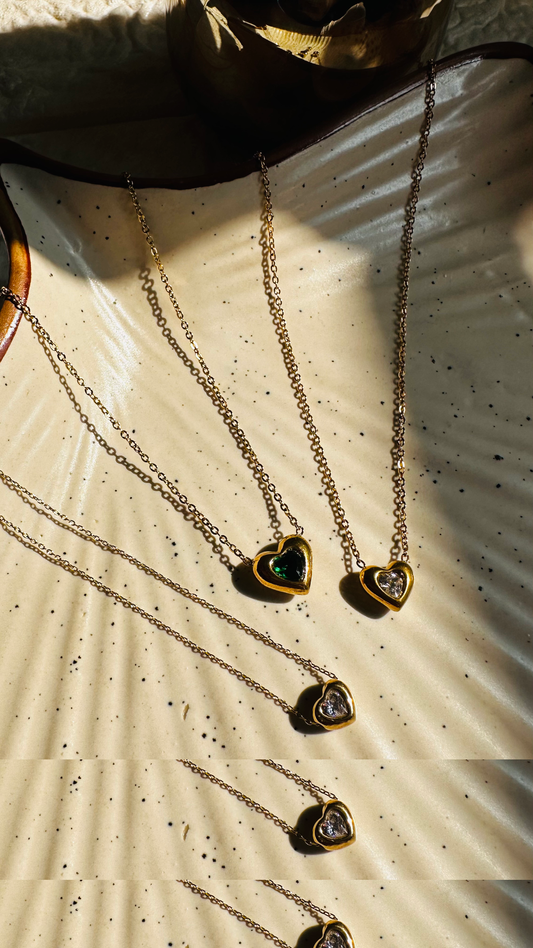 Heart-shaped jewelry on a textured surface with sunlight casting shadows