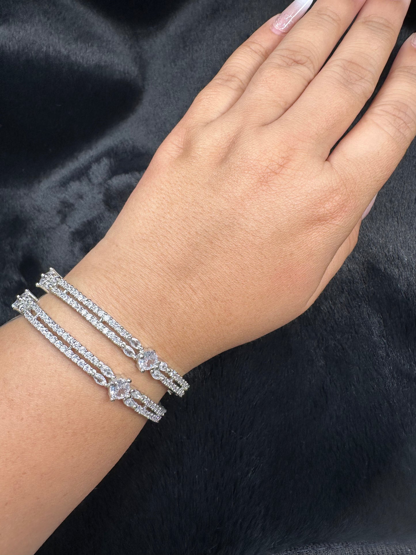 Flat lay of HeyBae silver bangle on fabric