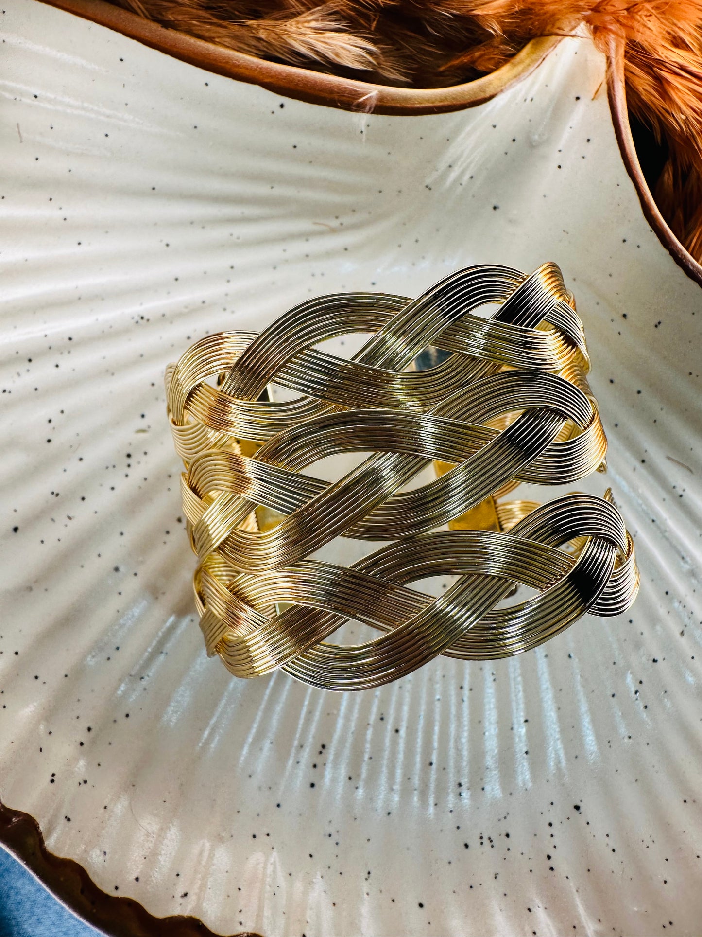 Woven gold cuff bracelet styled on hand for festive look