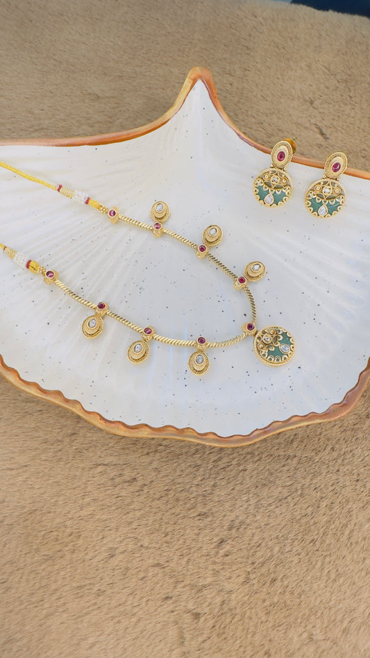 Jewelry set including necklace, bracelet, and earrings on a white dish with a beige background