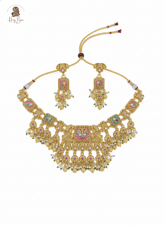 Gold necklace and earrings set with colorful gemstones on a white background
