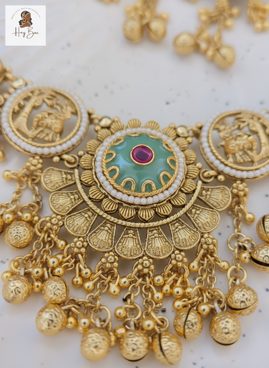 Close up of temple motif pendant with ruby stones and hanging gold beads.