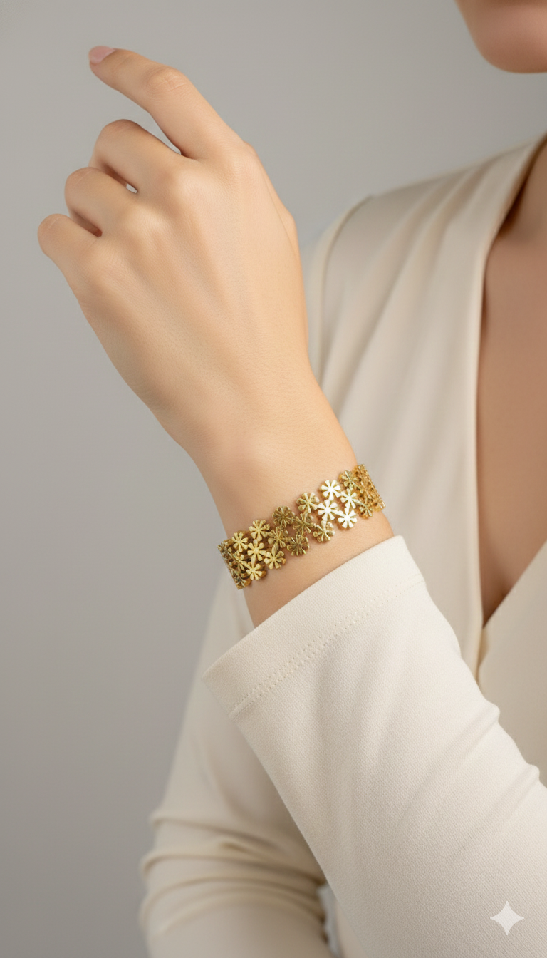 Gold bracelet on a person's wrist against a neutral background