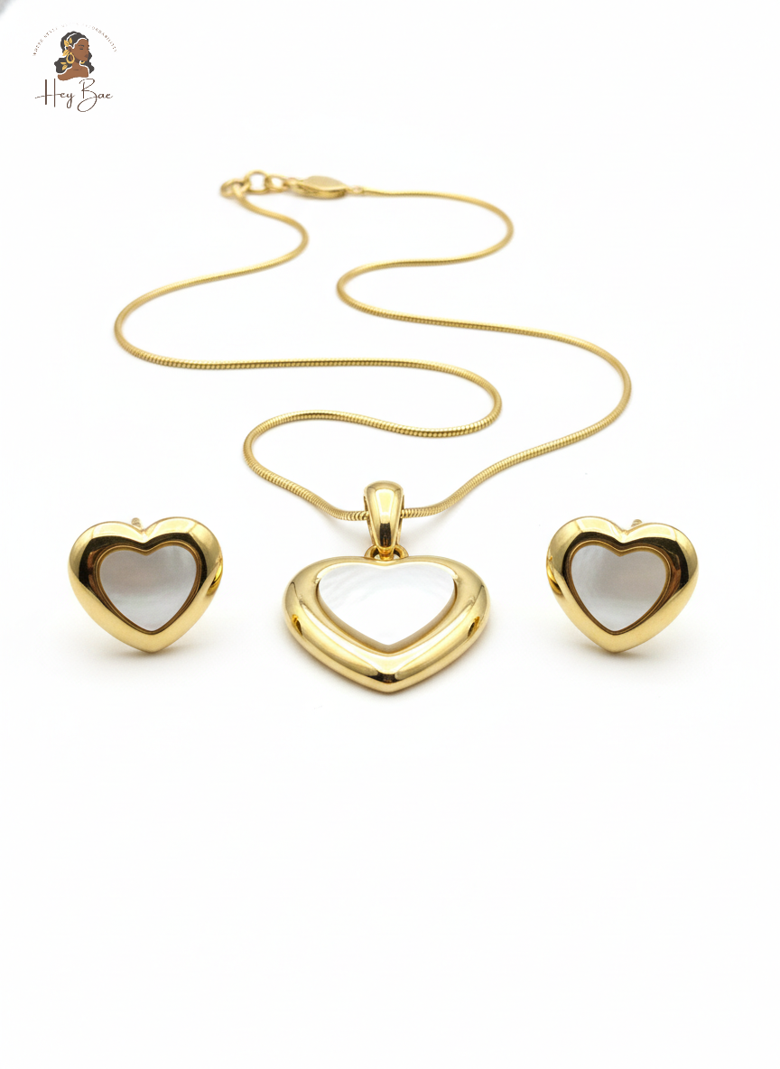 Gold heart-shaped jewelry set on a white background