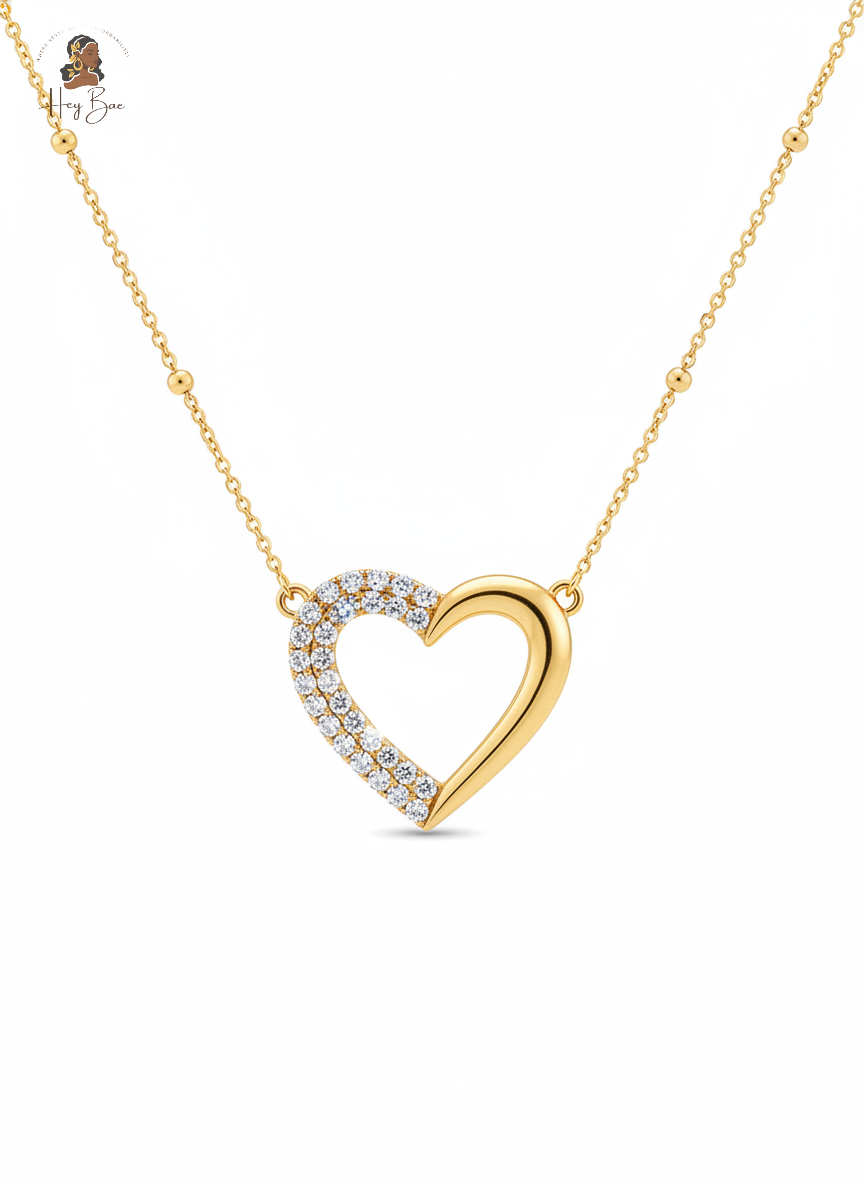 Gold heart-shaped necklace with diamonds on a white background
