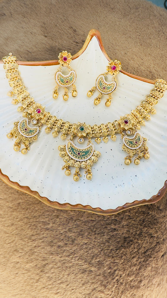 Gold necklace and earrings set on a white shell