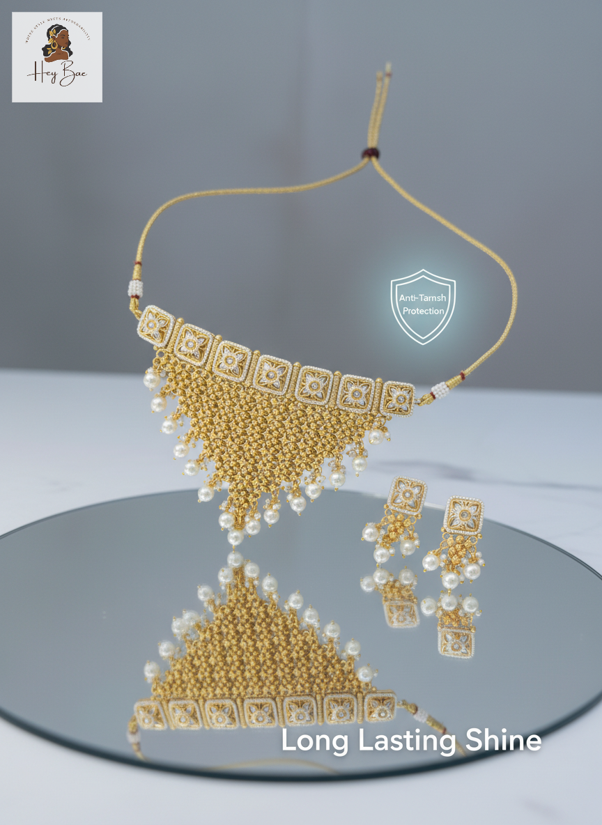 Gold necklace and earrings set on a reflective surface with 'Long Lasting Shine' text.