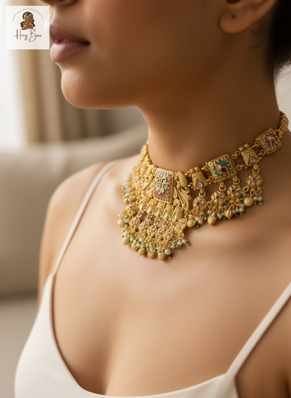 Gold necklace with green gemstones worn by a person, with a blurred background