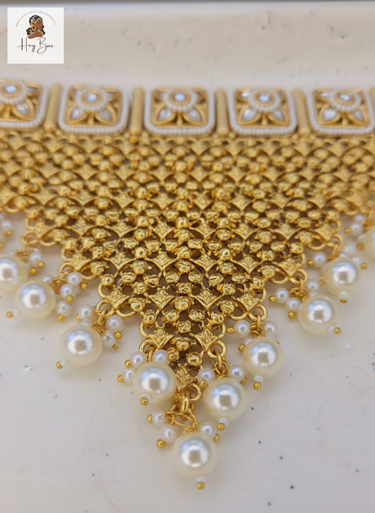 Gold necklace with pearls on a light background