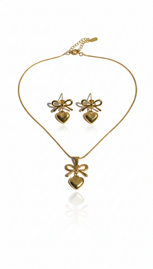 Gold plated bow and heart pendant and earrings set on a white background