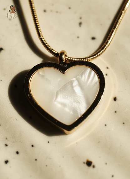 Heart-shaped pendant with a white stone on a speckled surface