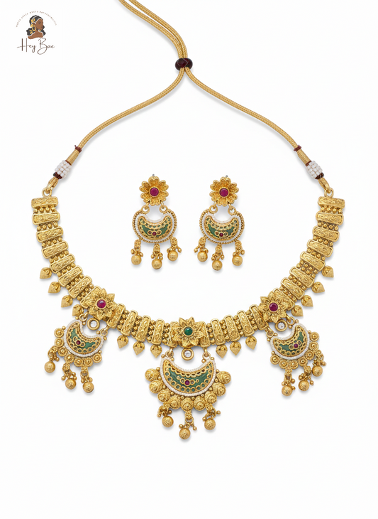 Gold necklace and earrings set with gemstones on a white background