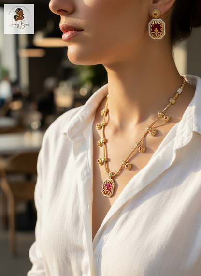 Close-up of a person wearing Hey Bae ruby red and gold geometric necklace set in an outdoor setting.