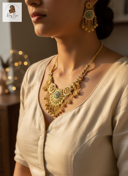 Woman wearing a gold necklace and earrings with a blurred background