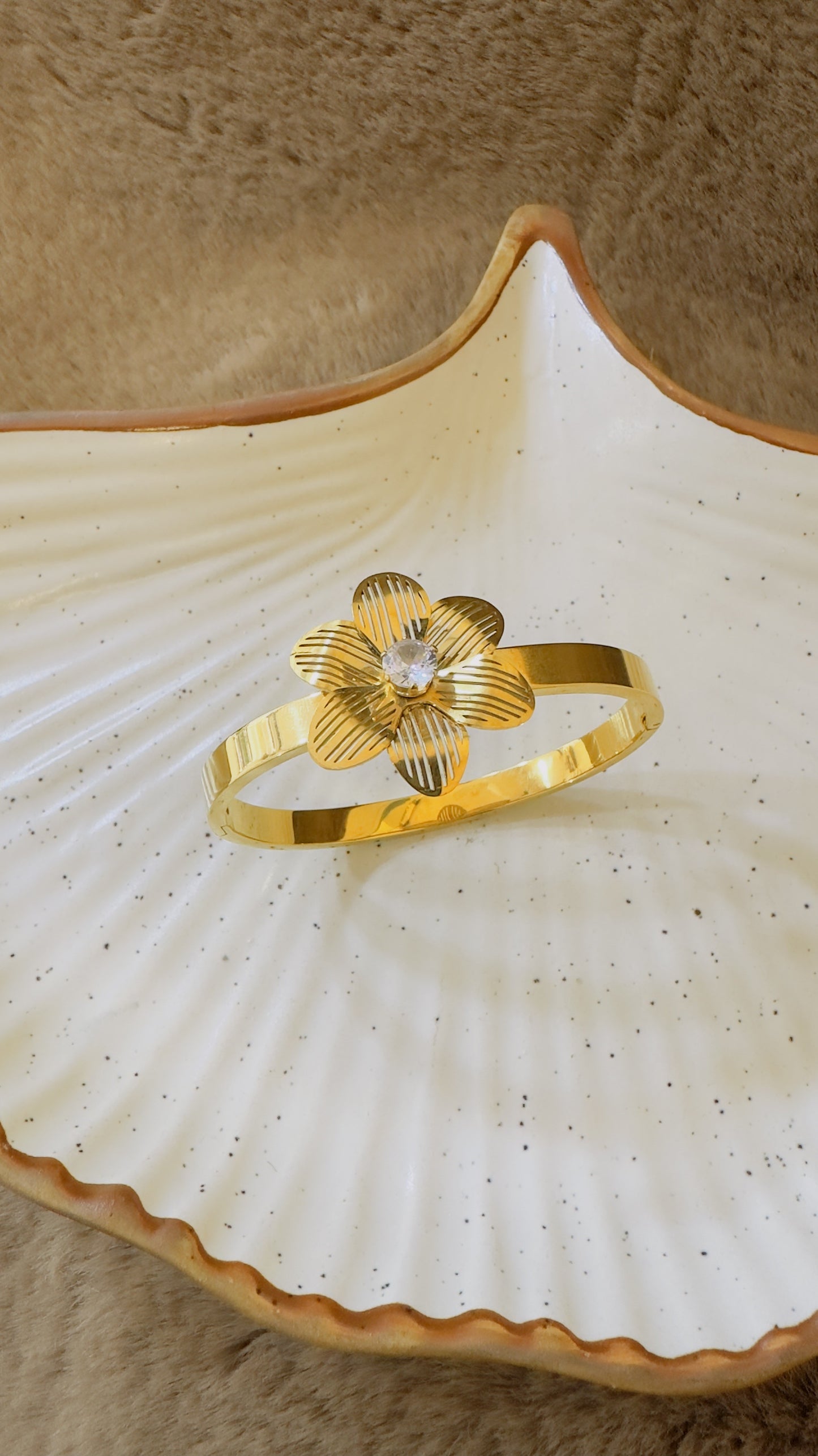 Gold plated anti tanish bracelet with a floral design on a white shell