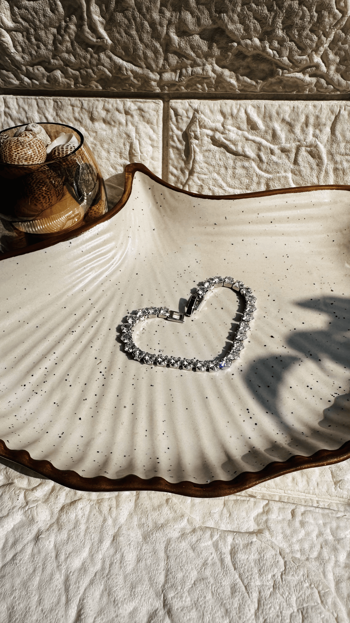 Silver solitaire tennis bracelet laid flat on white background