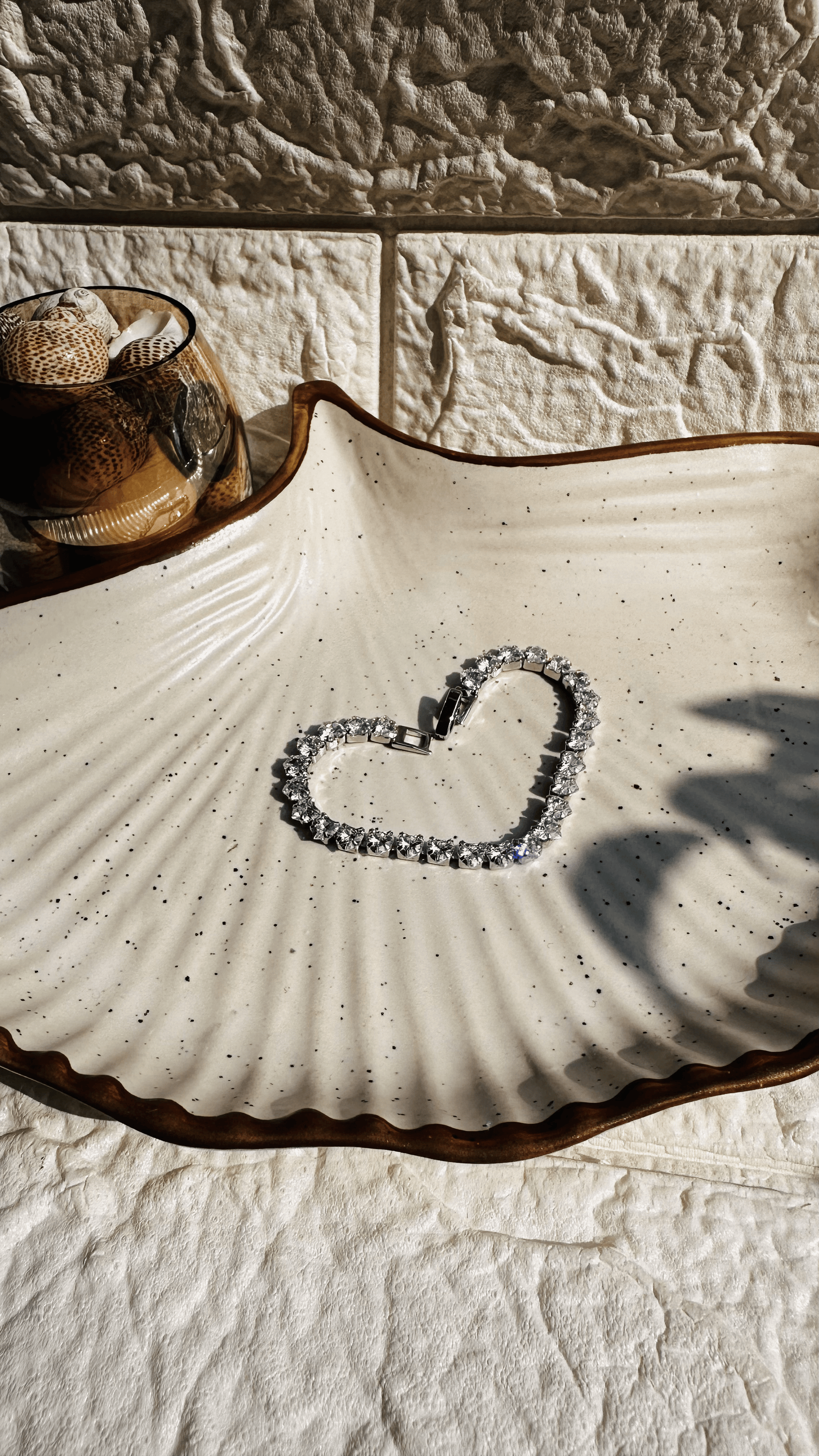 Silver solitaire tennis bracelet laid flat on white background