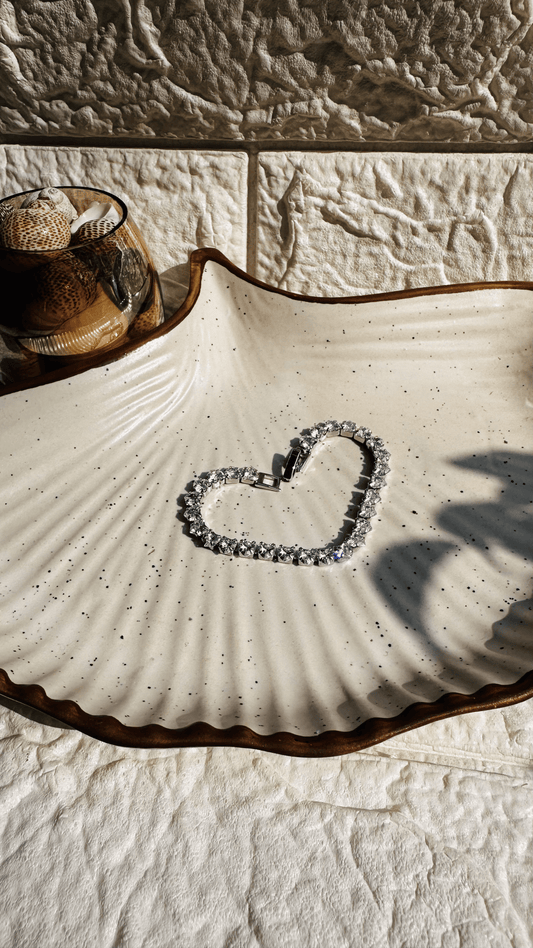 Silver solitaire tennis bracelet laid flat on white background