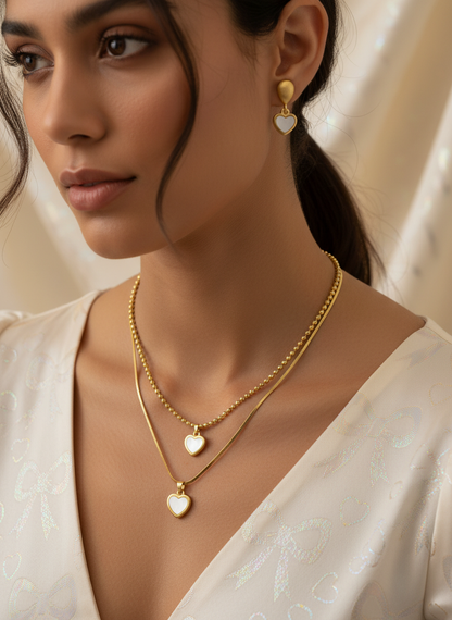 Woman wearing gold necklaces and earrings with a soft background