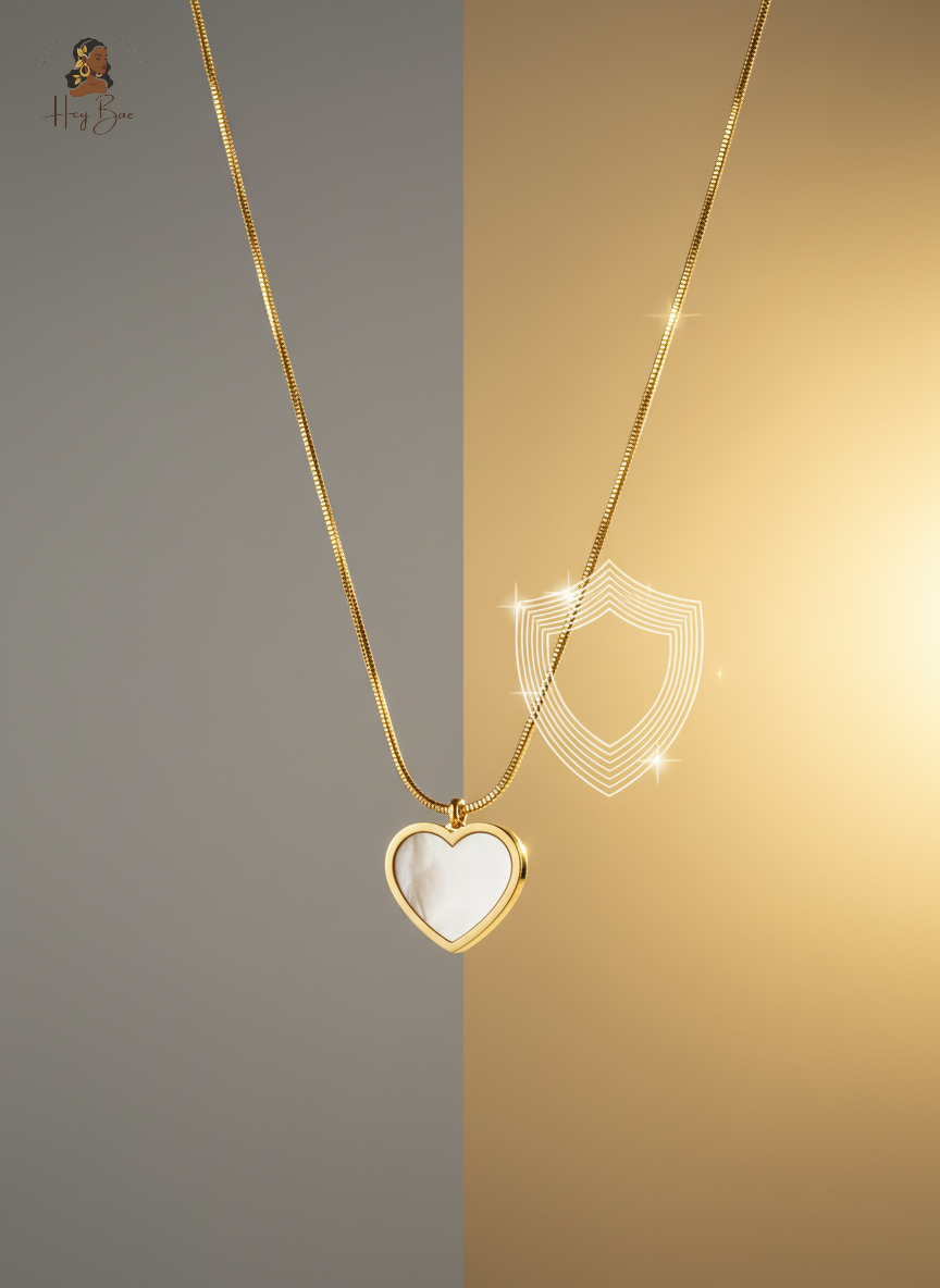Gold necklace with a heart-shaped pendant on a two-tone gray and gold background