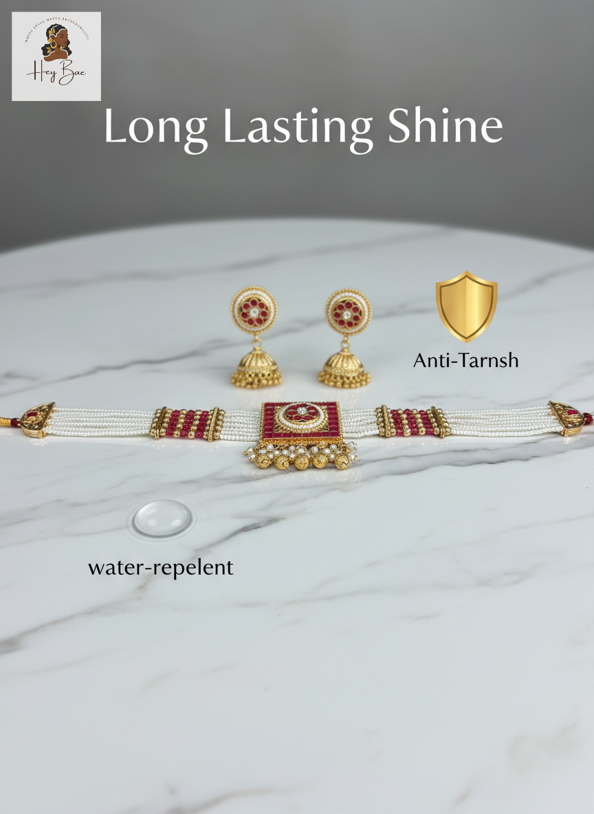 hey bae Royal Ruby Pearl Choker Set with Jhumkas - Gold Plated red accents on a marble surface, featuring 'Long Lasting Shine' text and an anti-tarnish symbol.