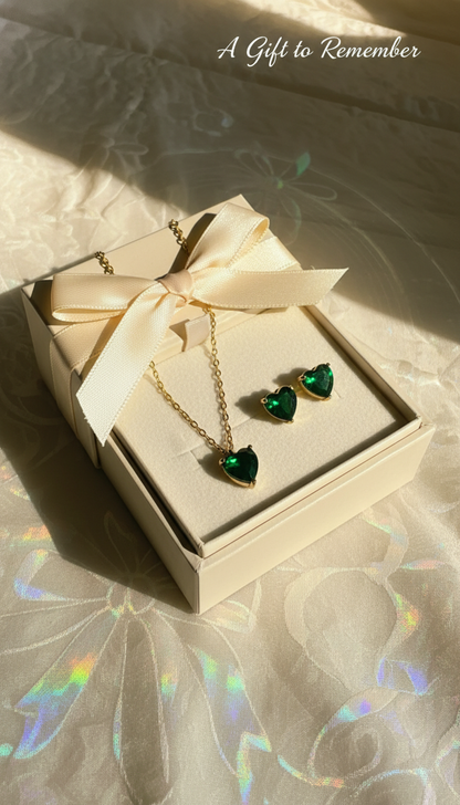 Heart-shaped jewelry set in a gift box with a bow on a textured surface.