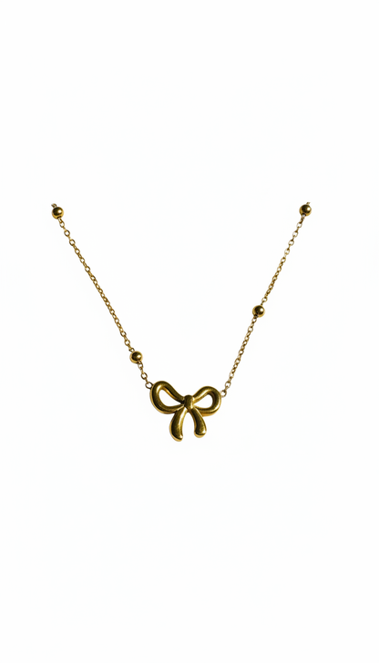 Gold bow-shaped necklace on a white background