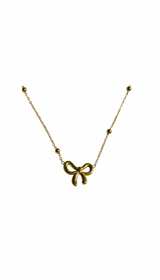 Gold bow-shaped necklace on a white background