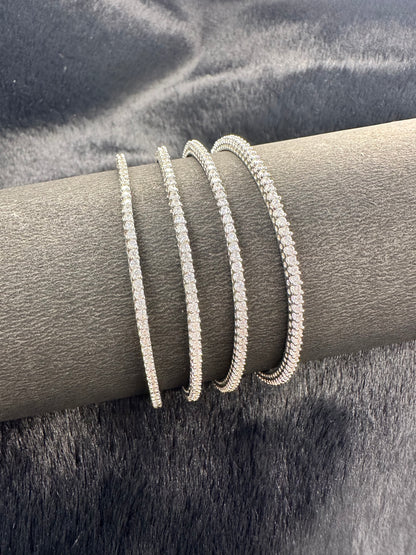 Flat lay photo of American Diamond bangles set of 4 on golden fabric background