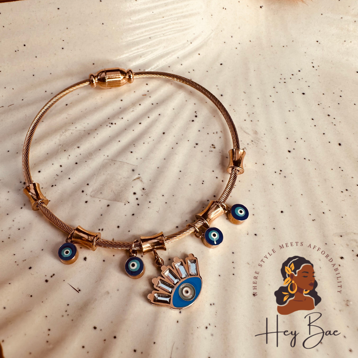 Flat lay of HeyBae Rose Gold Evil Eye Bangle – Anti-Tarnish Stainless Steel Bracelet