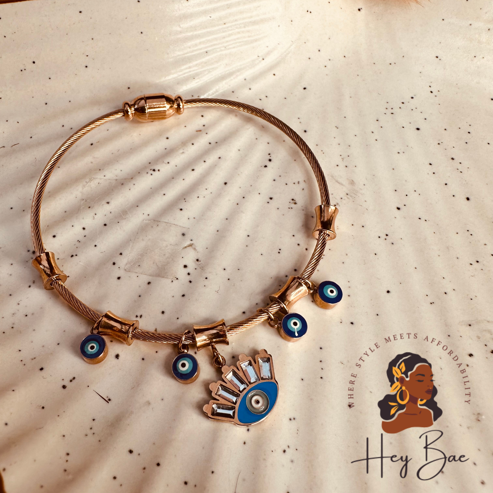 Flat lay of HeyBae Rose Gold Evil Eye Bangle – Anti-Tarnish Stainless Steel Bracelet