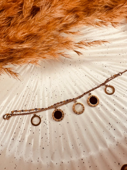 Flat lay of HeyBae anti-tarnish gold chain bracelet with Roman charm