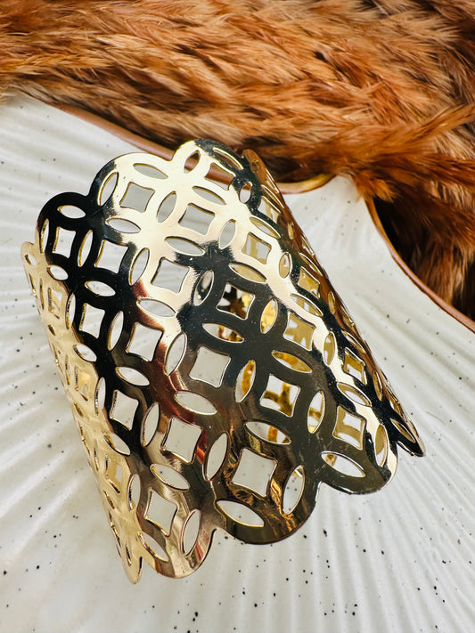Side profile of gold cuff bracelet set with cut-out ethnic pattern