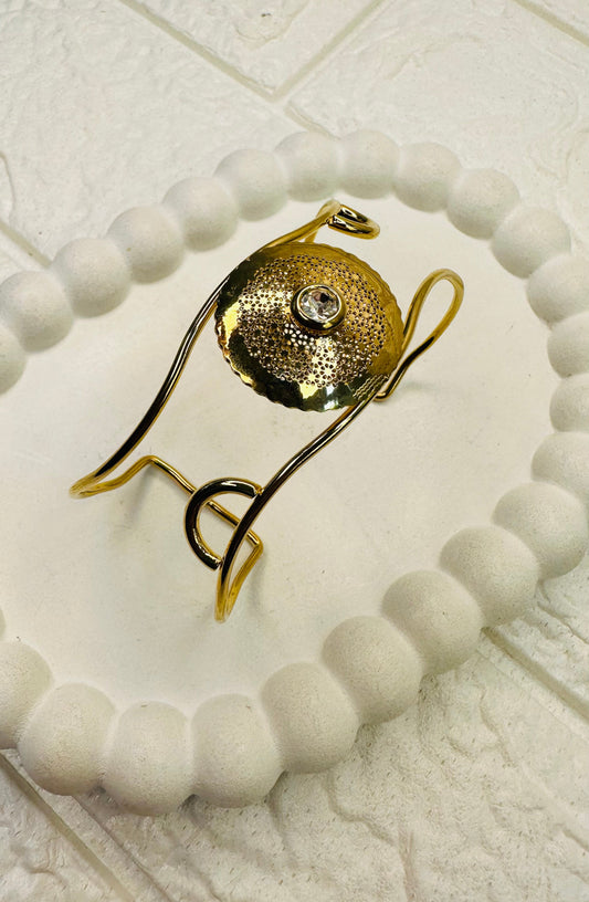 Gold disc pearl cuff bracelet with hammered design and stone centerpiece – front view