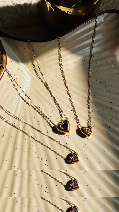 Heart-shaped jewelry on a textured surface with sunlight casting shadows