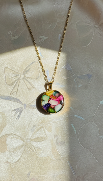 Necklace with a colorful pendant on a textured surface