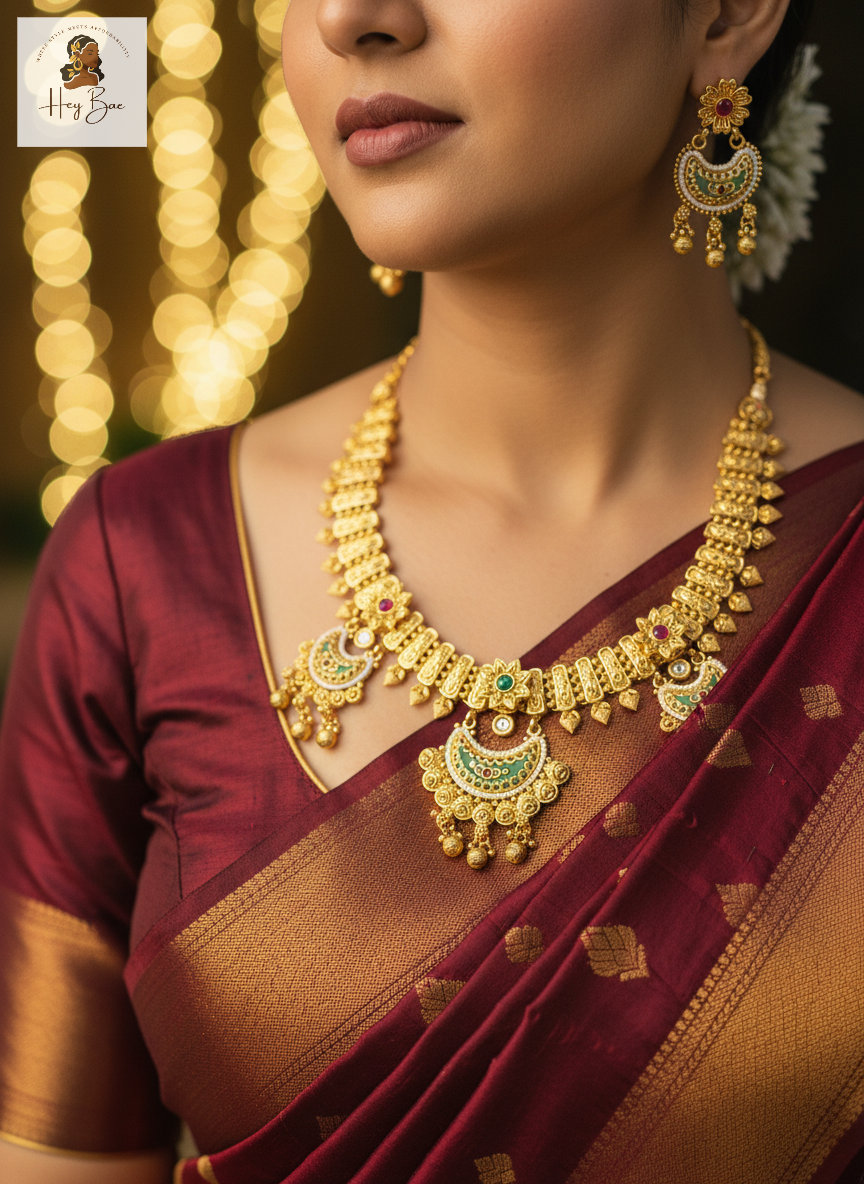 Woman wearing a gold necklace and earrings with a blurred bokeh background
