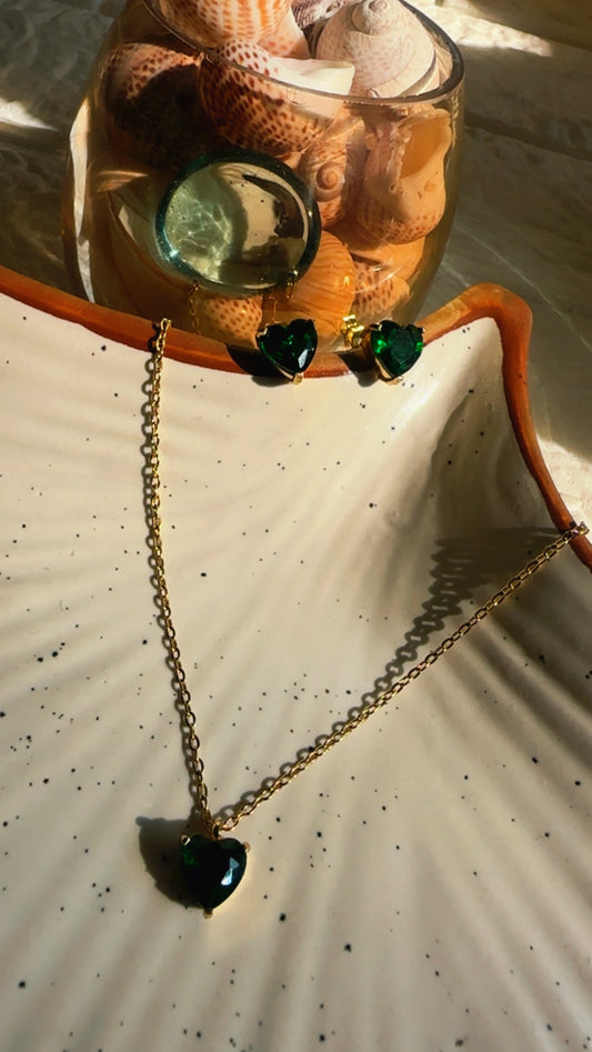 earrings with heart-shaped pendant on a textured surface